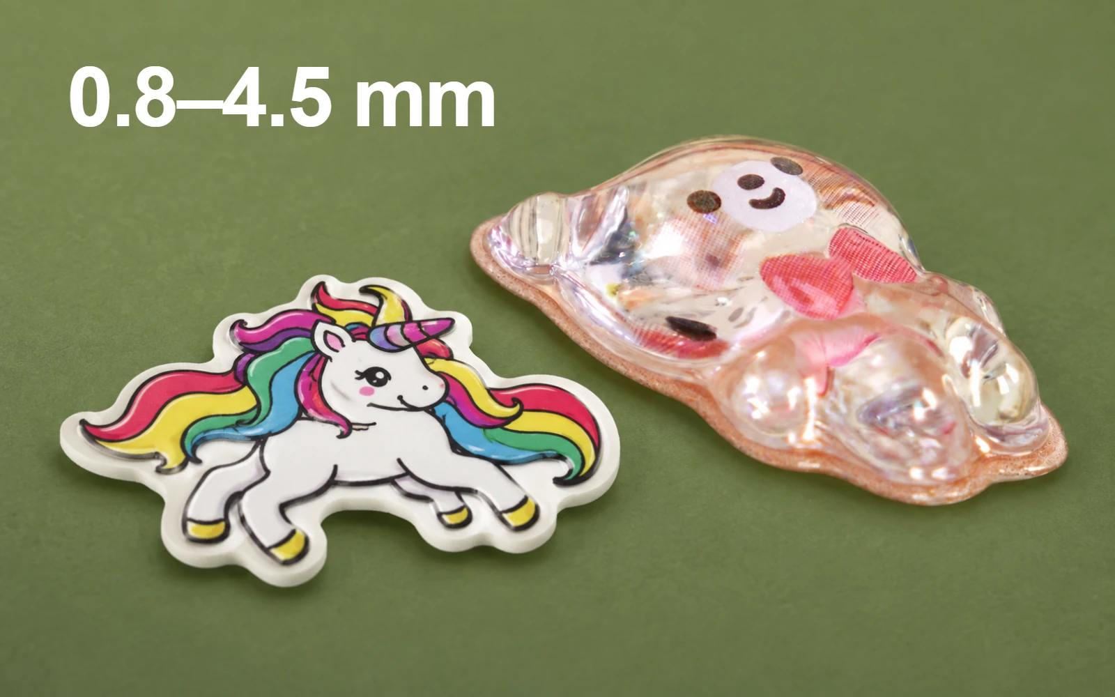 Thin foam unicorn sticker beside a raised molded bear sticker; custom thickness range 0.8–4.5 mm varies by structure.
