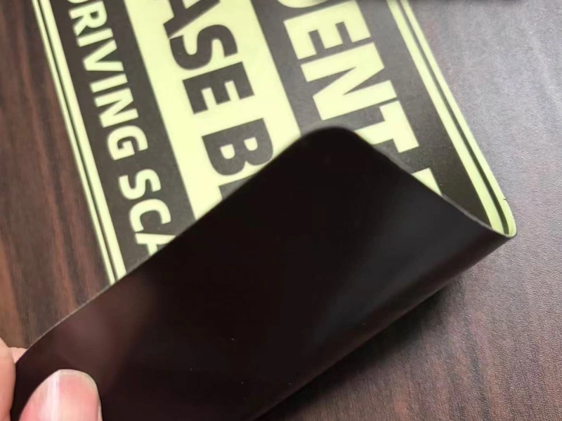 Custom glow-in-the-dark magnet bent to show flexible magnetic backing