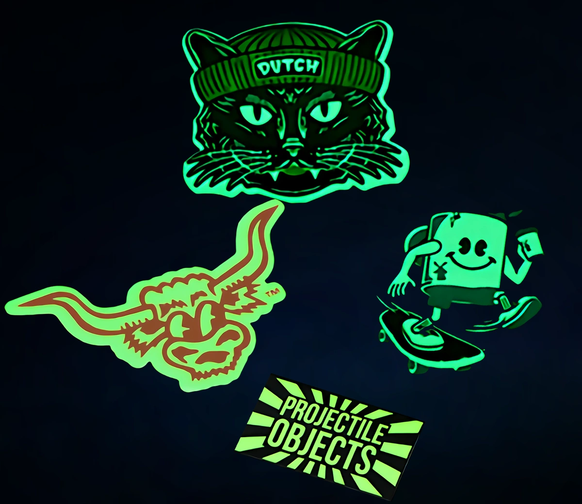 Custom glow-in-the-dark stickers and decals in assorted die-cut shapes glowing bright green in darkness